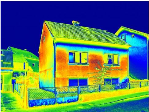 A thermal image of a detached house with green, blue and red areas showing 