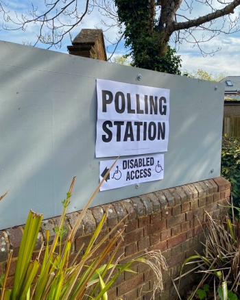 Polling station sign on a white background with disabled access sign underneath