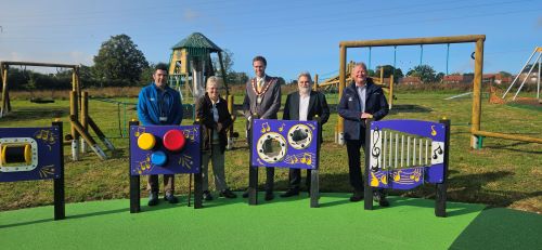 Councillors and staff standing by the play equipment in the new Whitewater Meadows play area