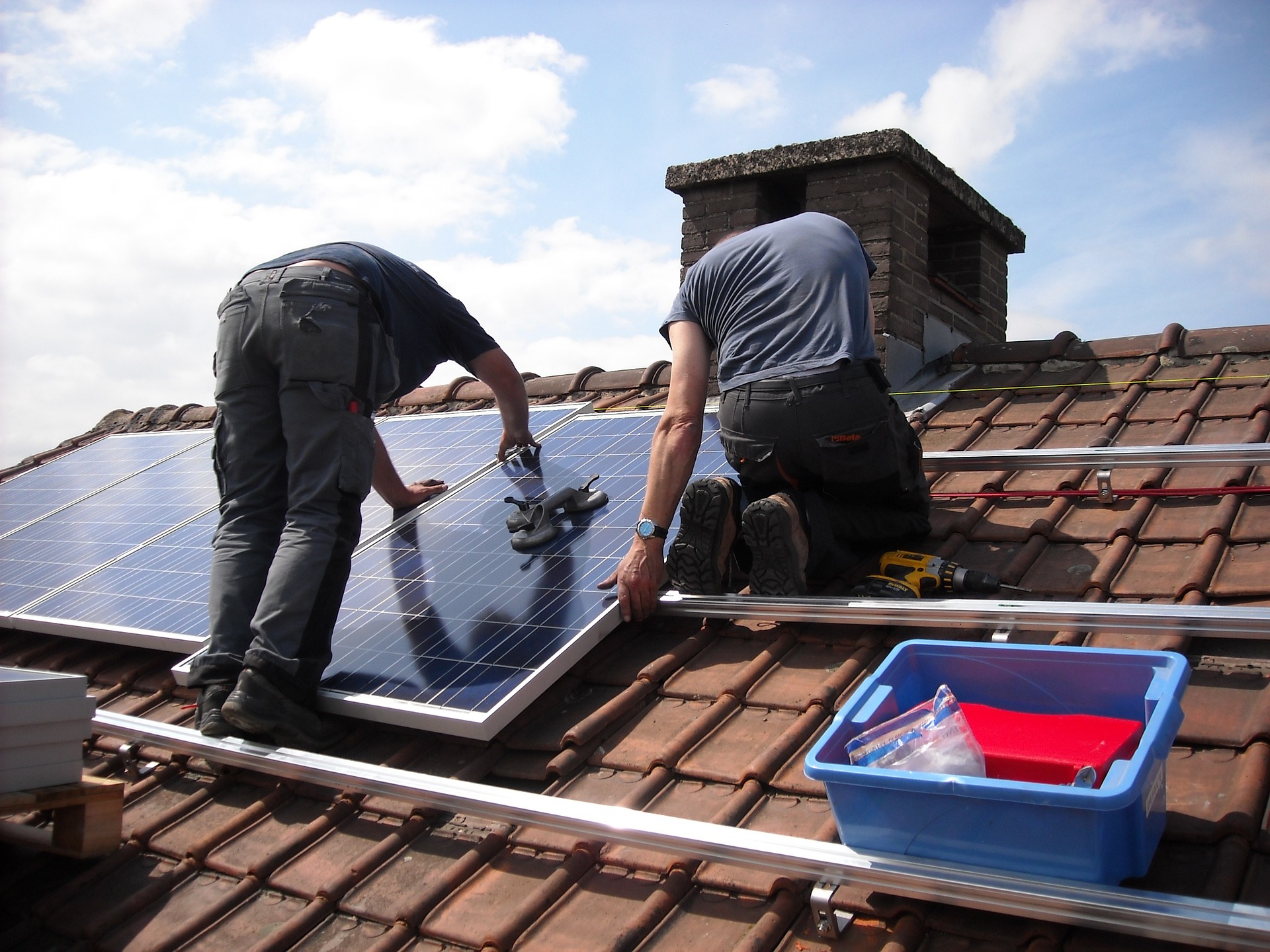 Men on roof of house fitting solar panels
