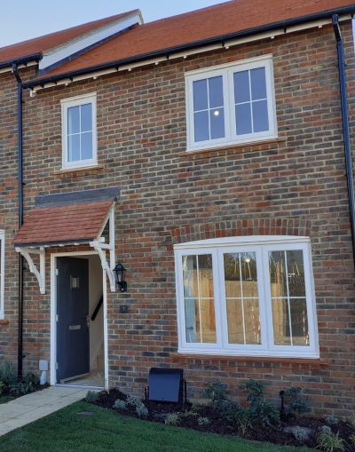 Front view of a red-bricked house with a open blue front door