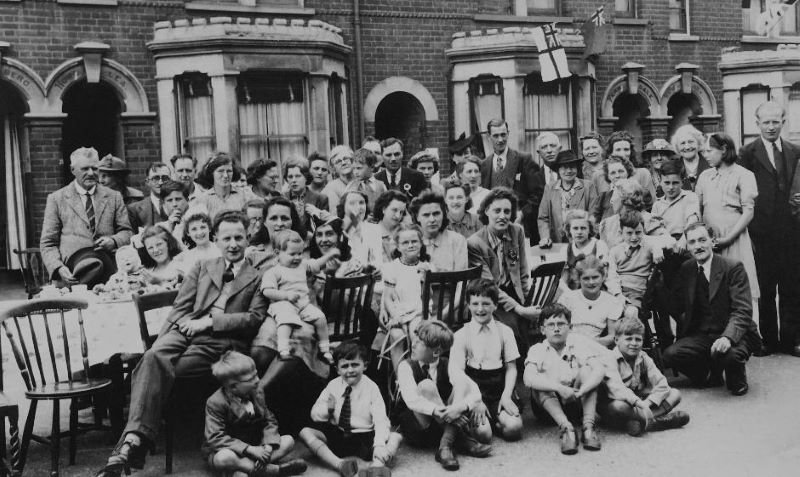 Black and white photo taken in 1945 of group of people having a street party