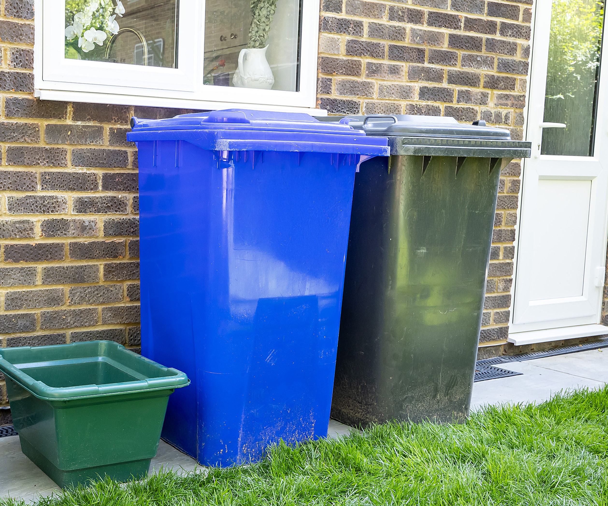 Glass crate with blue and black wheelie bins
