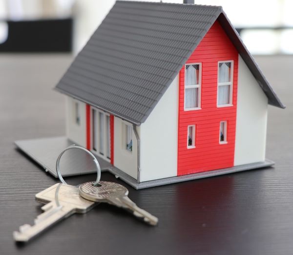 Model of a house with a house key on a house ring