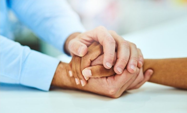 Two sets of hands holding each other