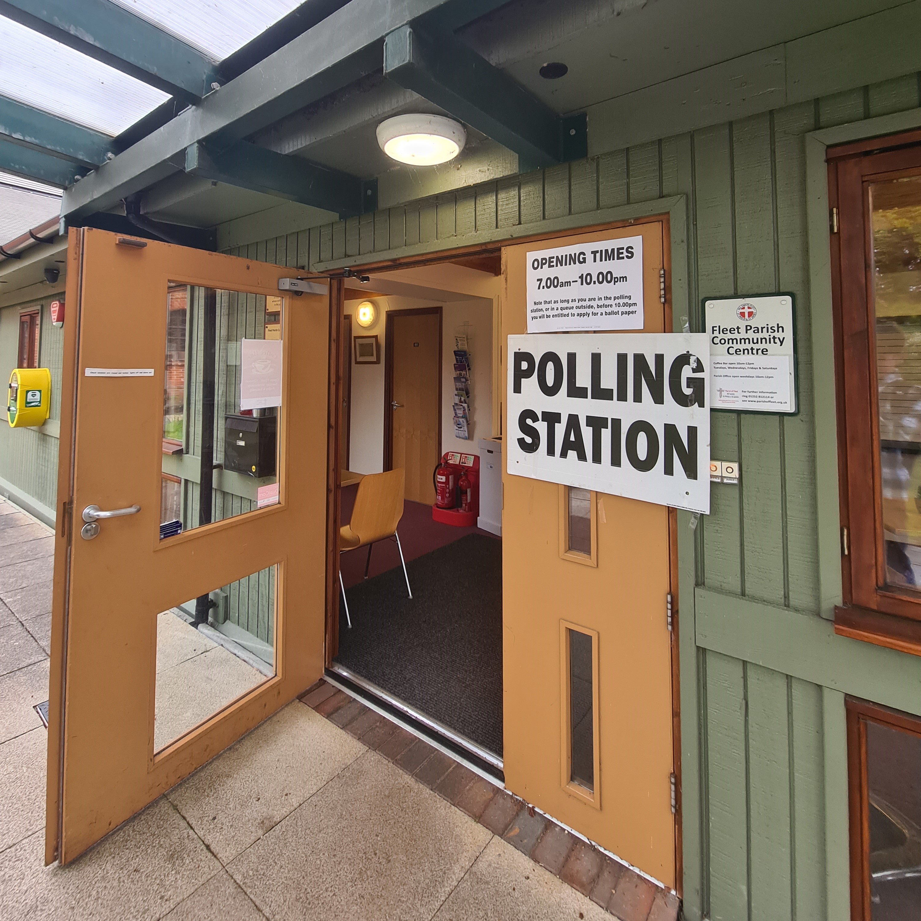Open door into a polling station with polling station sign
