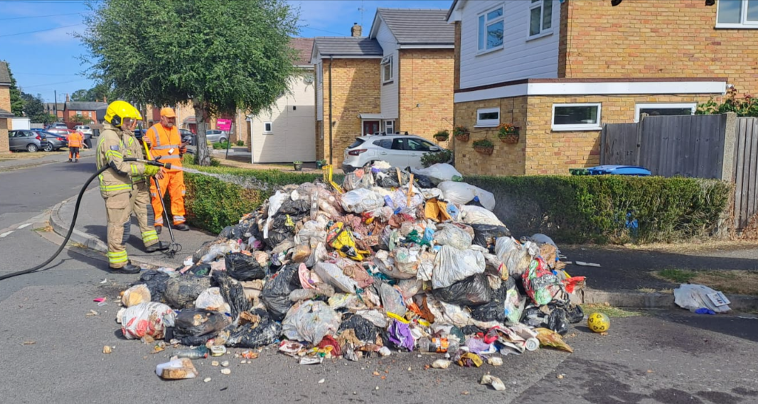 Fireman dousing a pile of rubbish 