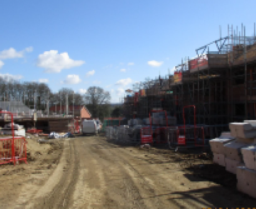Hawley Park Farm construction site showing progress of buildings and scaffolding over houses