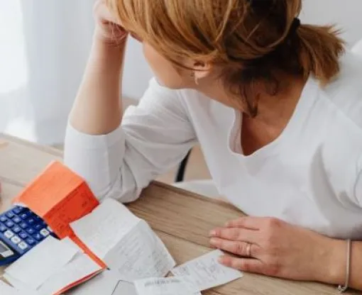 Women with head in hands surrounded by bills