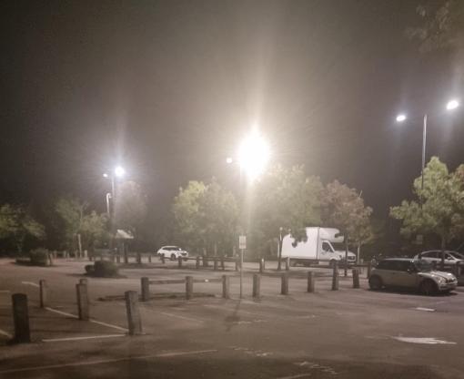 LED street lights in dark car park with cars in the background