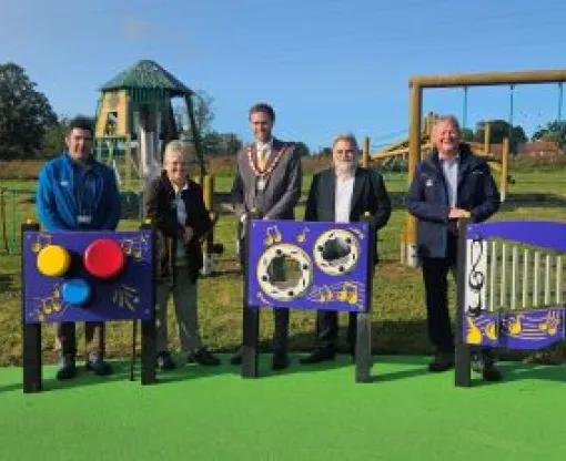 Councillors and staff standing by the play equipment in the new Whitewater Meadows play area
