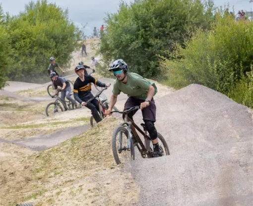 A group of cyclists riding along a hilly path