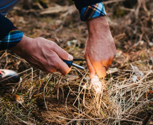 A man holding a lighter to flammable materials