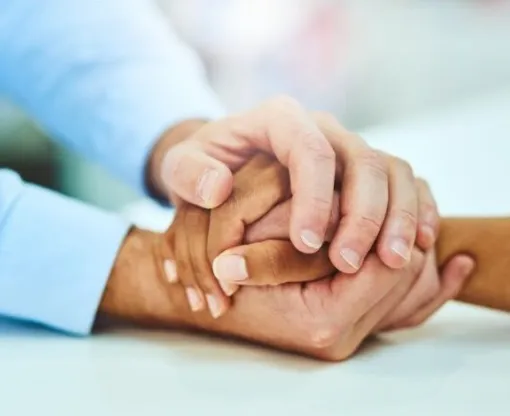 Two sets of hands holding each other