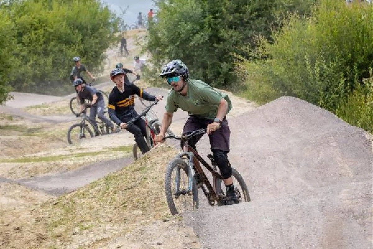 A group of cyclists riding along a hilly path