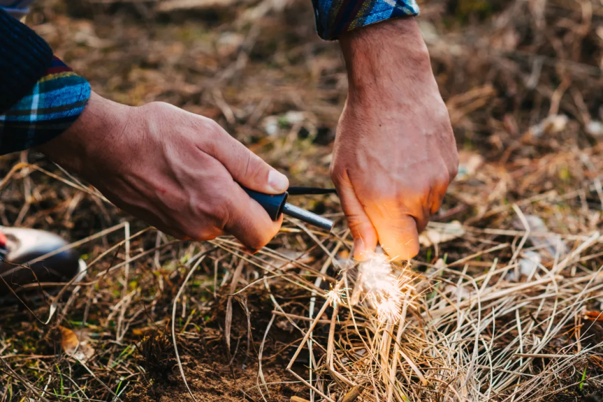 A man holding a lighter to flammable materials