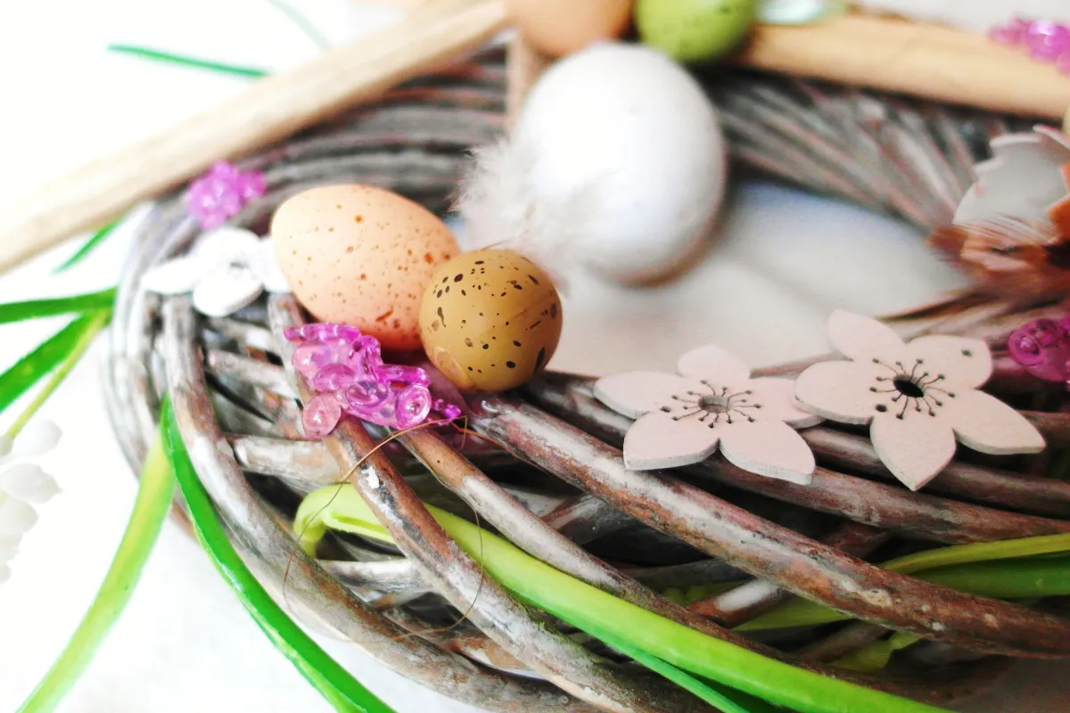 Small branches forming a circle, decorated with flowers and small eggs