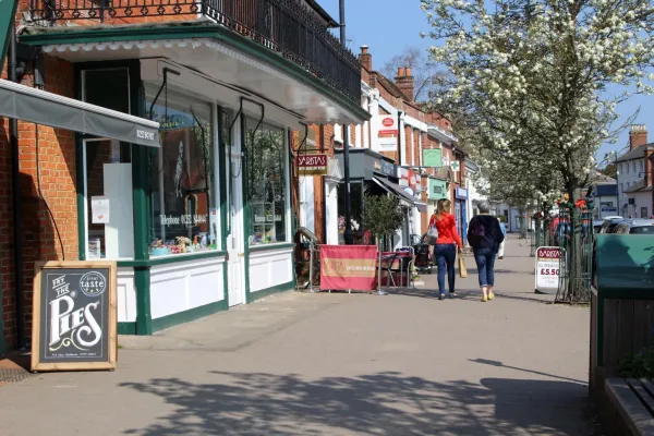 Two people walking past shops