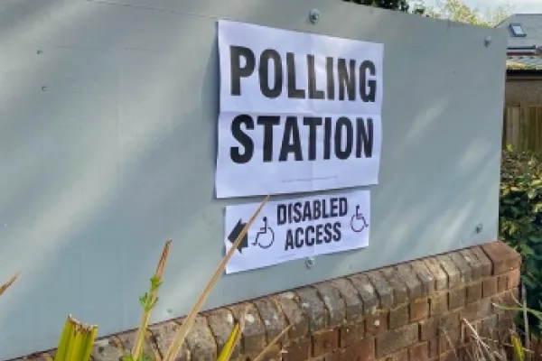 Polling station sign on a white background with disabled access sign underneath