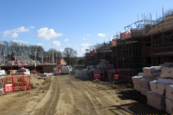 Hawley Park Farm construction site showing progress of buildings and scaffolding over houses