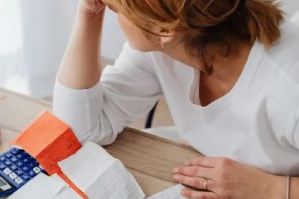 Women with head in hands surrounded by bills