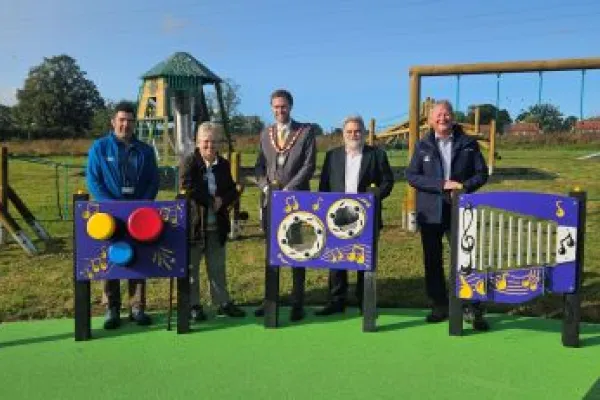 Councillors and staff standing by the play equipment in the new Whitewater Meadows play area