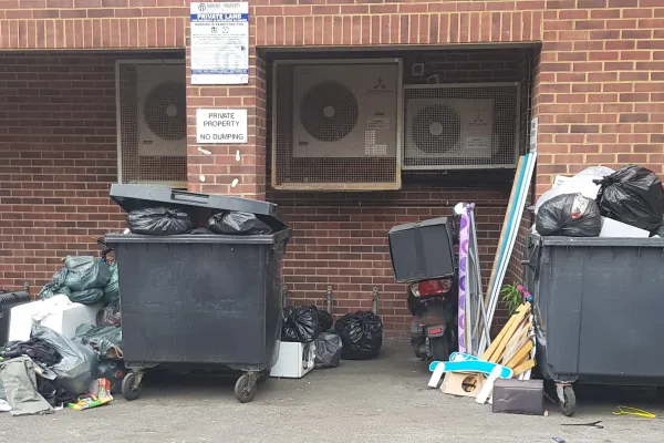 Fly-tipped rubbish by industrial bins