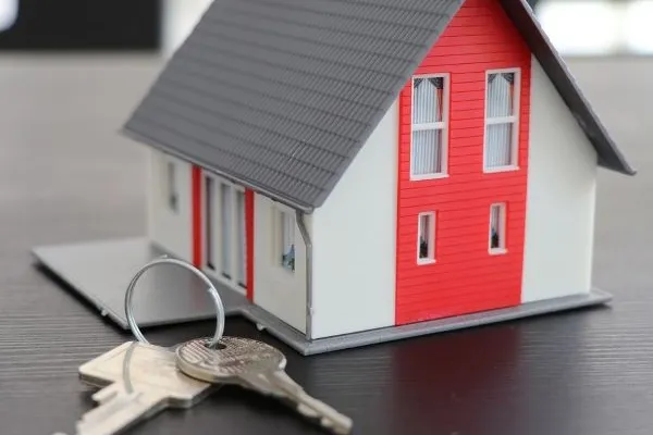 Model of a house with a house key on a house ring