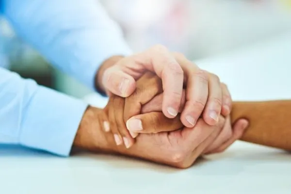 Two sets of hands holding each other