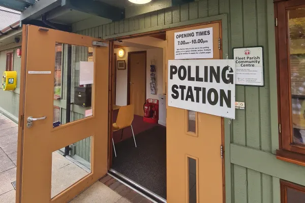 Open door into a polling station with polling station sign