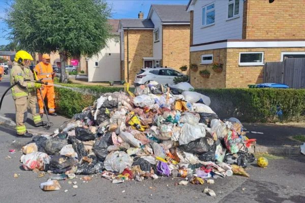 Fireman dousing a pile of rubbish 