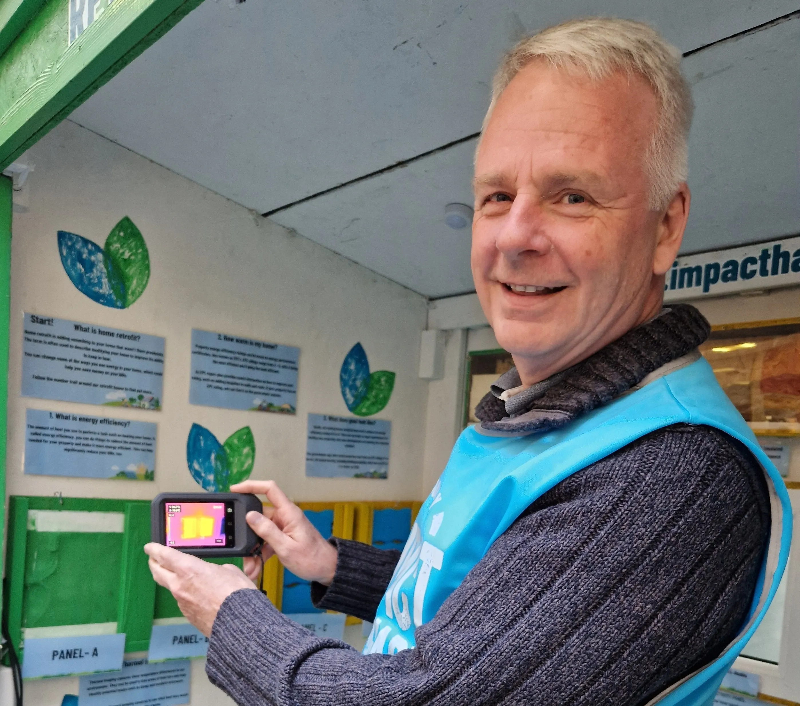 Photo of a smiling thermal imaging scheme volunteer holding a thermal imaging camera
