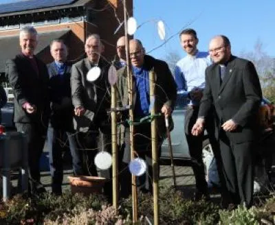 Clergy planting silver birch at Church on the Heath in Fleet