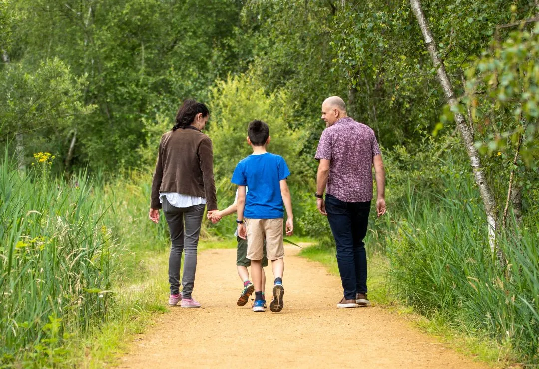 Family walking down a country path on Elvetham Heath