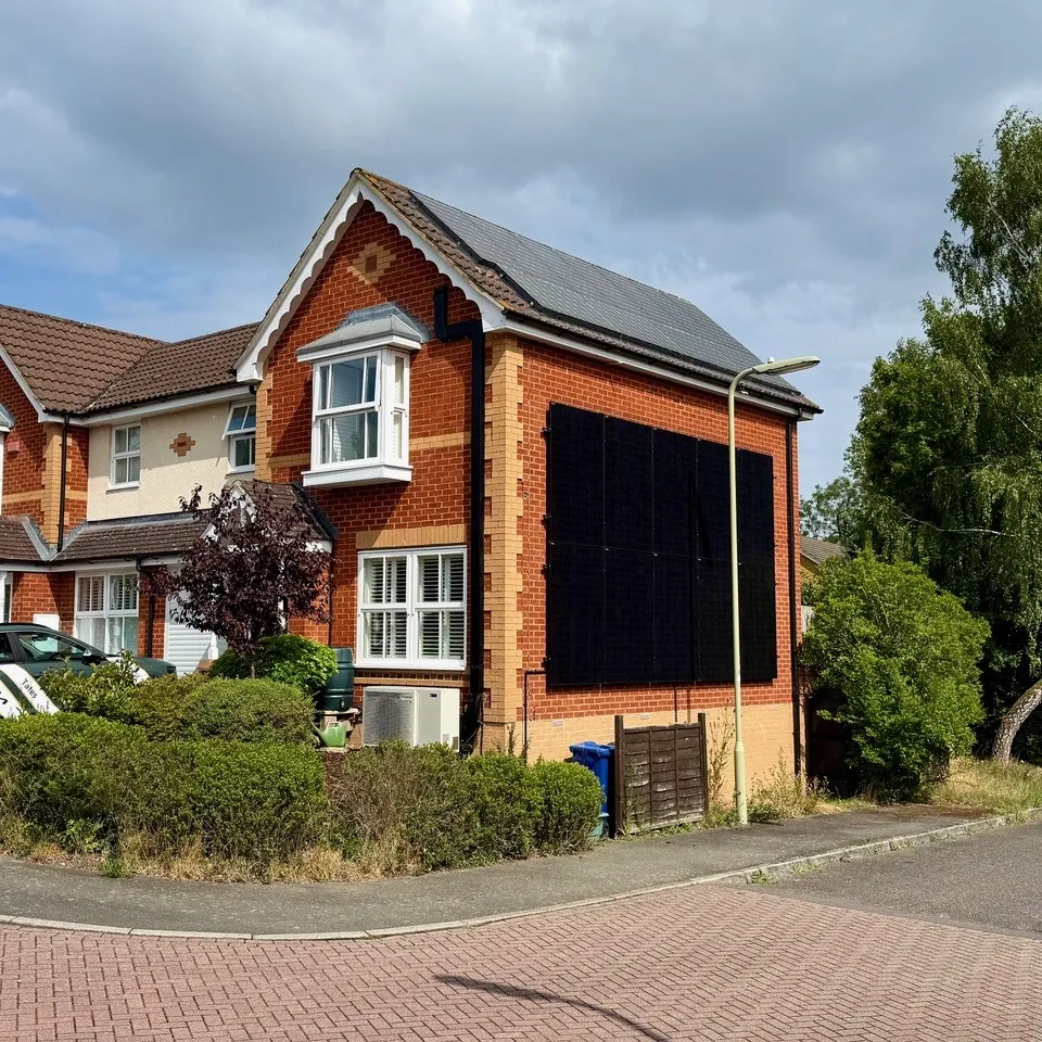 Photo of a house with a solar panel on the right hand wall