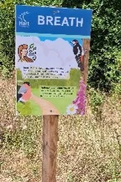A wooden sign post explaining what to do at point seven. The text is mirrored on the webpage.